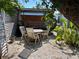 Charming outdoor seating area featuring a wooden table, chairs, and lush landscaping at 4408 125Th W St, Cortez, FL 34215