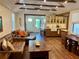 Open-concept living space with exposed beam ceiling, hardwood floors, cozy leather seating, and seamless flow to the kitchen at 4408 125Th W St, Cortez, FL 34215