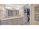 Bright bathroom featuring double sinks, white cabinetry, and walk in closet at 4500 Gulf Of Mexico Dr # Ph4, Longboat Key, FL 34228