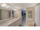 Bright bathroom featuring double sinks, white cabinetry, and walk in closet at 4500 Gulf Of Mexico Dr # Ph4, Longboat Key, FL 34228