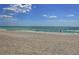 Sandy beach with a few people enjoying the sunny day with a blue sky above at 4500 Gulf Of Mexico Dr # Ph4, Longboat Key, FL 34228