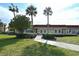 Exterior view of the clubhouse featuring well-manicured landscaping, a sidewalk, and classic architectural design at 4500 Gulf Of Mexico Dr # Ph4, Longboat Key, FL 34228