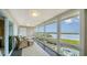 Inviting sunroom features wicker furniture and expansive windows offering stunning waterfront views at 4500 Gulf Of Mexico Dr # Ph4, Longboat Key, FL 34228