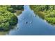 People enjoy kayaking on a river with lush vegetation on either side at 4500 Gulf Of Mexico Dr # Ph4, Longboat Key, FL 34228