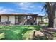 Backyard featuring a lush green lawn, a beautiful tree, and glass enclosed patio at 4722 Oak Hill Ln # 44, Sarasota, FL 34232
