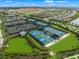 Expansive aerial view of tennis and pickleball courts in a community with lakes and construction at 4726 Zeno Ct, Bradenton, FL 34211