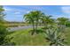 Beautiful backyard with lush grass, landscaping, lake view, and palm trees enhancing the outdoor space at 4726 Zeno Ct, Bradenton, FL 34211