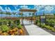 Community garden with raised flower beds, lush landscaping, and a welcome sign at the gated entrance at 4726 Zeno Ct, Bradenton, FL 34211