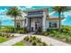 Clubhouse exterior features a tiled roof, well manicured landscaping and clear blue skies with palm trees at 4726 Zeno Ct, Bradenton, FL 34211
