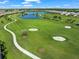 Scenic aerial shot of a lush golf course featuring well-maintained greens, meandering paths, and pristine sand traps at 4726 Zeno Ct, Bradenton, FL 34211