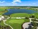Aerial view of a scenic golf course with a large lake, pristine greens, and golf carts at 4726 Zeno Ct, Bradenton, FL 34211