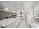 A modern kitchen showcases white cabinetry, marble countertops and stainless steel appliances and a view to the living room at 4726 Zeno Ct, Bradenton, FL 34211