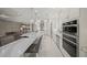 A modern kitchen features white cabinetry, marble countertops and stainless steel appliances and a view to the living room at 4726 Zeno Ct, Bradenton, FL 34211