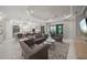 A stylish living room shows neutral decor with a large sectional, with a seamless transition into the modern kitchen at 4726 Zeno Ct, Bradenton, FL 34211