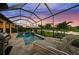 Screened-in pool with a covered patio, poolside seating, and a view of the lake at 4726 Zeno Ct, Bradenton, FL 34211