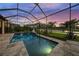 Screened-in pool with a covered patio with lights, overlooking the lake at 4726 Zeno Ct, Bradenton, FL 34211