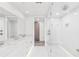 Bright, modern bathroom featuring dual sinks, marble countertops, and a glass-enclosed shower at 516 Tamiami S Trl # 102, Nokomis, FL 34275