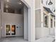 Exterior shot of the building entrance showing concrete sidewalks and walls with double glass doors at 516 Tamiami S Trl # 102, Nokomis, FL 34275