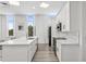 Sleek kitchen with white cabinetry, marble countertops, and large windows, offering a bright and airy space at 516 Tamiami S Trl # 102, Nokomis, FL 34275
