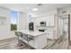 Modern kitchen featuring white cabinetry, stainless steel appliances, a marble countertop island, and bar stool seating at 516 Tamiami S Trl # 102, Nokomis, FL 34275