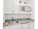 Convenient kitchenette featuring granite countertops, a sink, microwave, and mini-fridge at 516 Tamiami S Trl # 102, Nokomis, FL 34275