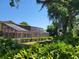 Beautiful backyard featuring a screened pool, lush landscaping, and mature shade trees at 5340 Dominica Cir, Sarasota, FL 34233