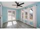 Bedroom with stylish flooring, a ceiling fan, three windows, and glass doors to the lanai at 5340 Dominica Cir, Sarasota, FL 34233
