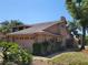 Side exterior showcasing the garage and the mature landscaping with various plants and shrubs at 5340 Dominica Cir, Sarasota, FL 34233