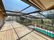 Lanai with wooden floors overlooking the pool area and green backyard at 5340 Dominica Cir, Sarasota, FL 34233