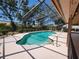 An inviting pool is surrounded by a screened-in lanai with lush landscaping at 5340 Dominica Cir, Sarasota, FL 34233