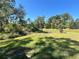 Expansive grassy backyard with mature trees, offering a serene natural setting at 5473 Gagnon Ter, North Port, FL 34291