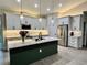 Elegant kitchen features white cabinetry, a center island with quartz countertops, and energy-efficient stainless steel appliances at 5473 Gagnon Ter, North Port, FL 34291