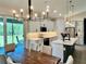 Bright, modern kitchen features a center island, stainless appliances, and white cabinets adjacent to dining table at 5473 Gagnon Ter, North Port, FL 34291