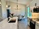 Well-appointed kitchen with a center island, white cabinets, stainless appliances, and stylish lighting for a luxurious feel at 5473 Gagnon Ter, North Port, FL 34291