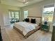 Bright main bedroom featuring tray ceilings, windows on two walls, and an attached outdoor living area at 5473 Gagnon Ter, North Port, FL 34291