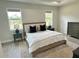Relaxing main bedroom featuring tray ceilings, a neutral color palette, and views of the outside at 5473 Gagnon Ter, North Port, FL 34291