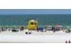 Beach scene featuring beachgoers and a yellow lifeguard tower, under a clear sky at 5502 Shadow Lawn Dr, Sarasota, FL 34242
