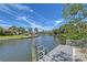 Waterfront canal view featuring private docks with ladders and beautiful surrounding landscaping at 5502 Shadow Lawn Dr, Sarasota, FL 34242
