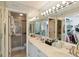 Bright and spacious bathroom with a double sink vanity, mirrored walls, and a walk-in shower at 5624 Ashton Lake Dr # 5624, Sarasota, FL 34231