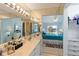 Bathroom with a dual sink vanity, large mirror, and an open view to the main bedroom and walk in closet at 5624 Ashton Lake Dr # 5624, Sarasota, FL 34231