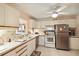 Compact kitchen featuring a full-sized refrigerator and white cabinets at 5624 Ashton Lake Dr # 5624, Sarasota, FL 34231