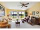 Inviting living room with a ceiling fan and windows showcasing water views and white shutters at 5624 Ashton Lake Dr # 5624, Sarasota, FL 34231