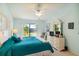 A serene main bedroom featuring a plush bed, white dresser, ceiling fan, and serene views of the pond at 5624 Ashton Lake Dr # 5624, Sarasota, FL 34231