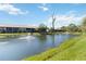 Exterior view of a multi-story condo complex overlooking a pond with a fountain and lush landscaping at 5624 Ashton Lake Dr # 5624, Sarasota, FL 34231