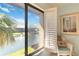 Relaxing view of a pond with fountain from a window with white shutters and a wicker chair in the foreground at 5624 Ashton Lake Dr # 5624, Sarasota, FL 34231