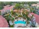Aerial shot of community featuring a sparkling pool, lush landscaping, and colorful residential buildings at 5691 Bentgrass Dr # 15-101, Sarasota, FL 34235
