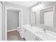 Bathroom featuring double sinks, hard surface floors, and a door to a toilet room at 5691 Bentgrass Dr # 15-101, Sarasota, FL 34235