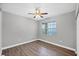 This is a bedroom featuring wood floors, ceiling fan, and a window letting in natural light at 5691 Bentgrass Dr # 15-101, Sarasota, FL 34235