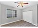 This is a bedroom with a ceiling fan, wood floors, a window, and a closet at 5691 Bentgrass Dr # 15-101, Sarasota, FL 34235