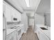 Galley kitchen featuring white appliances, hardwood flooring, and bright modern cabinets at 5691 Bentgrass Dr # 15-101, Sarasota, FL 34235